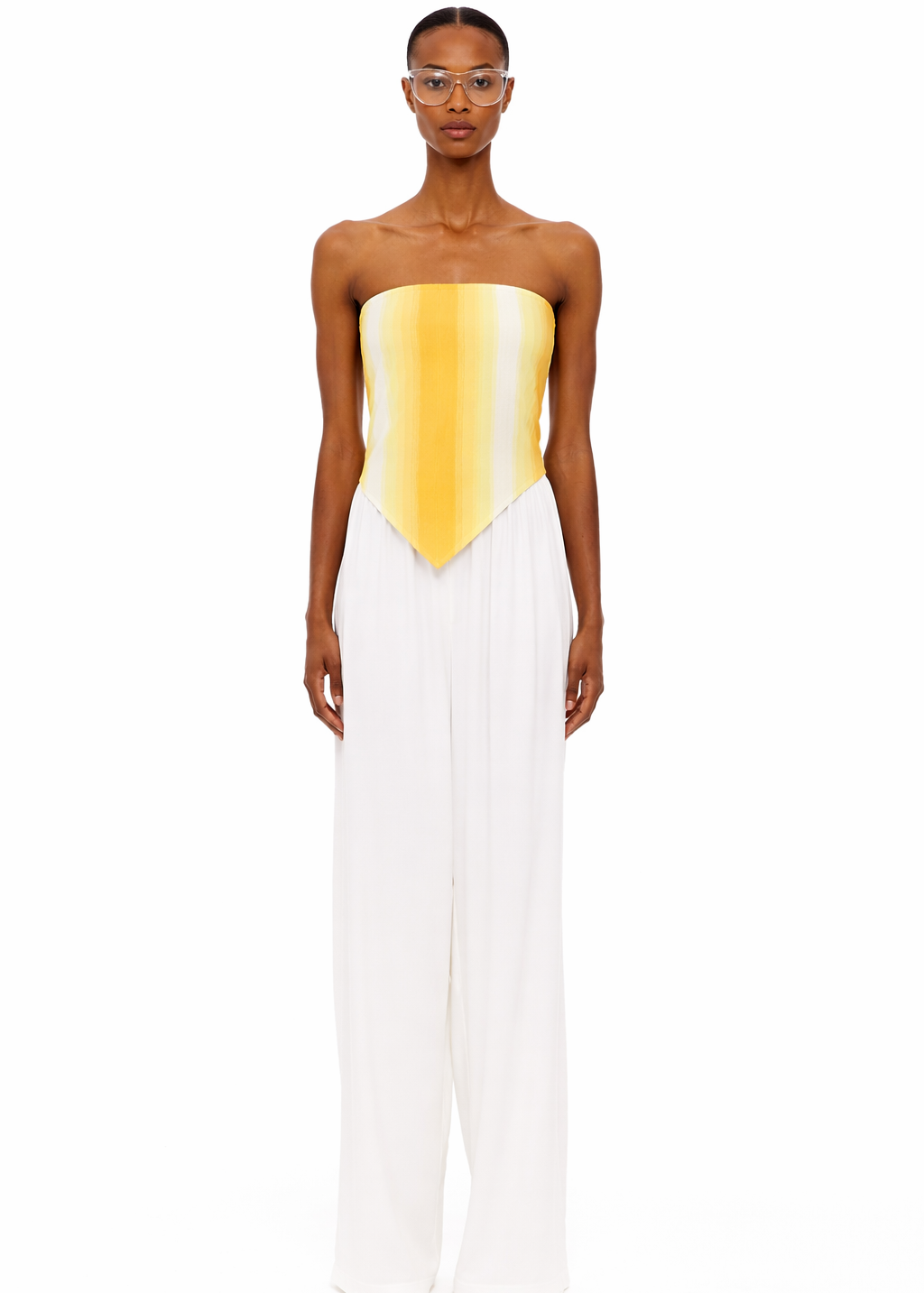 Wearing The Triangle Top—a strapless, yellow-to-white gradient piece crafted with sustainable Marrakech fashion techniques—and high-waisted, wide-leg white pants, the person stands facing forward against a plain white background.