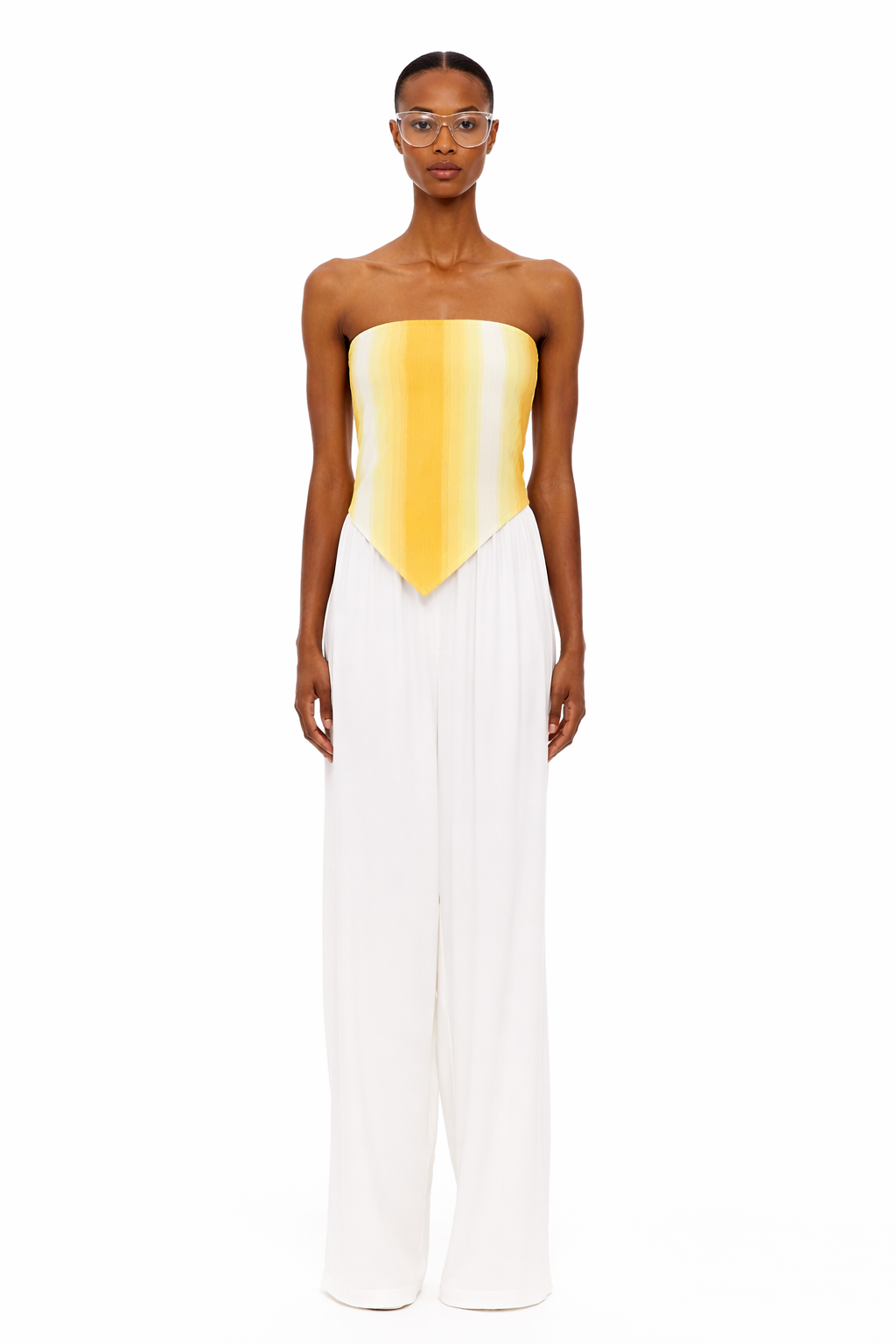 Wearing The Triangle Top—a strapless, yellow-to-white gradient piece crafted with sustainable Marrakech fashion techniques—and high-waisted, wide-leg white pants, the person stands facing forward against a plain white background.