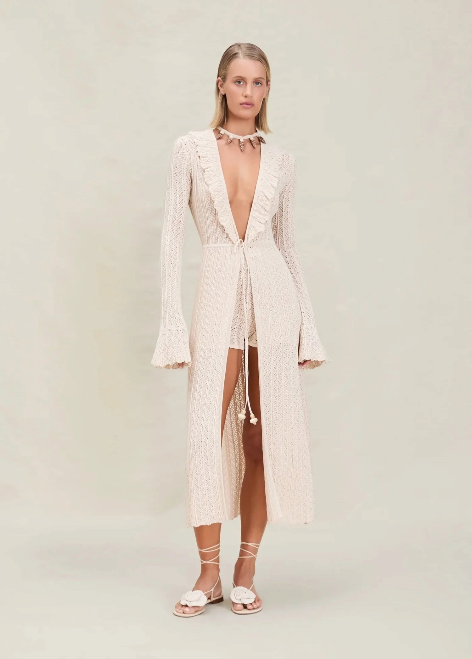 Model wearing KABE SHOP INC Christine Short in cream knit with matching long-sleeved open robe and lace-up sandals.
