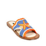 The Mazu Slide is a flat sandal featuring a blue upper with orange trim and a beaded starfish embellishment on top. Inspired by Silk Route artisan footwear, this open-toe sandal is finished with a tan sole, making it perfect for effortless summer style.