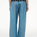 Back view of the Mateo Pant, featuring wide-leg trousers in blue and teal vertical stripes with a black elastic waistband.