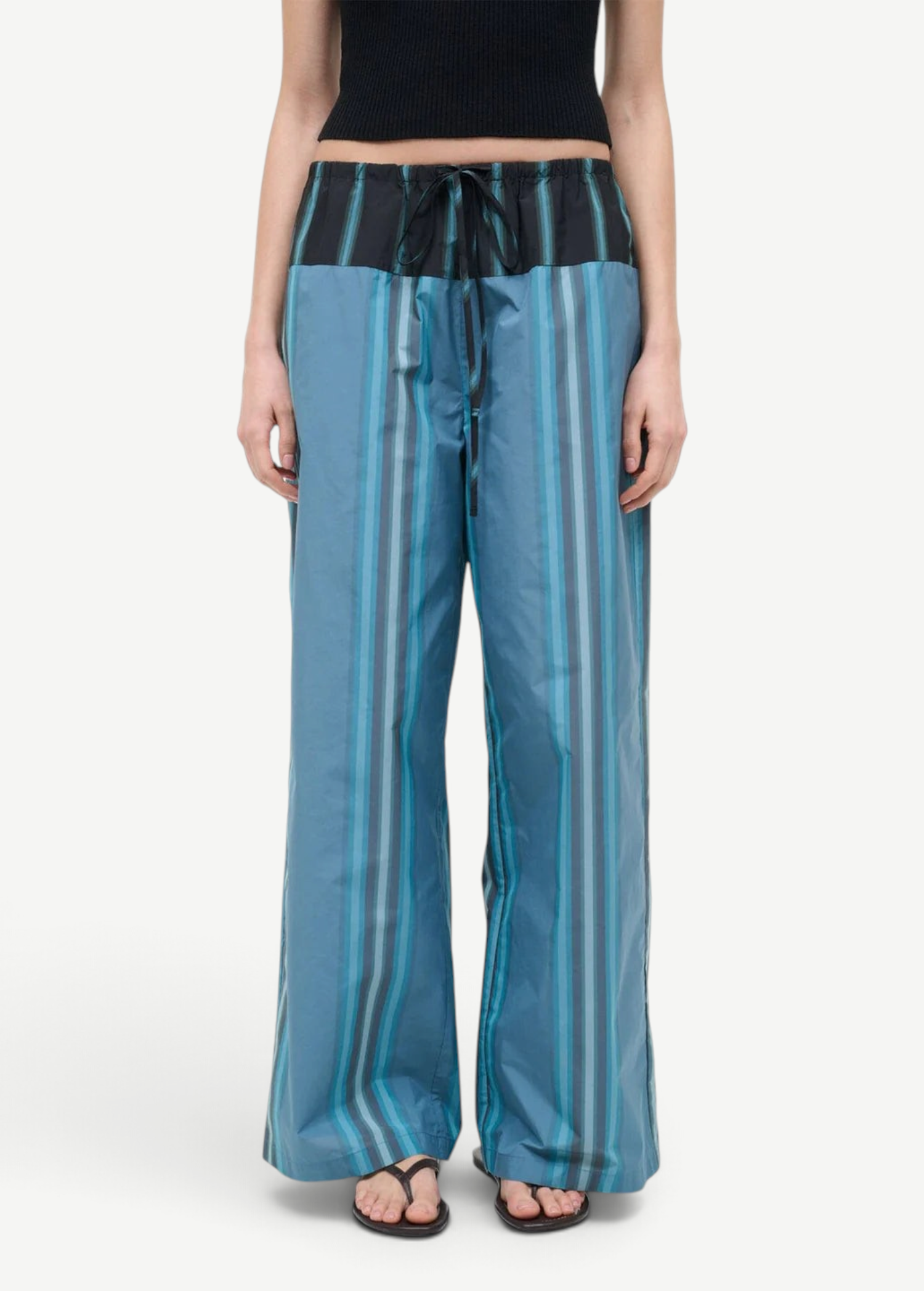 Mateo Pant wide-leg trousers featuring a blue and dark green vertical stripe pattern with a black drawstring waistband.