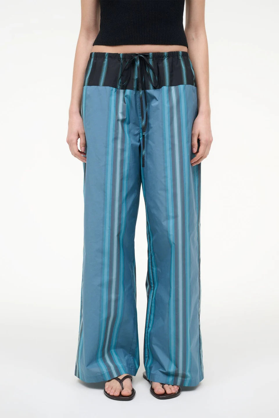 Mateo Pant wide-leg trousers featuring a blue and dark green vertical stripe pattern with a black drawstring waistband.