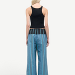A person seen from behind wears a black ribbed tank top and Mateo Pant wide-leg trousers, featuring blue vertical stripes and a dark contrasting waistband.