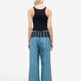 A person seen from behind wears a black ribbed tank top and Mateo Pant wide-leg trousers, featuring blue vertical stripes and a dark contrasting waistband.
