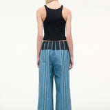A person seen from behind wears a black ribbed tank top and Mateo Pant wide-leg trousers, featuring blue vertical stripes and a dark contrasting waistband.