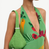 KABE SHOP INC Demy shoulder bag in bright green beaded texture worn over the shoulder with a matching floral dress