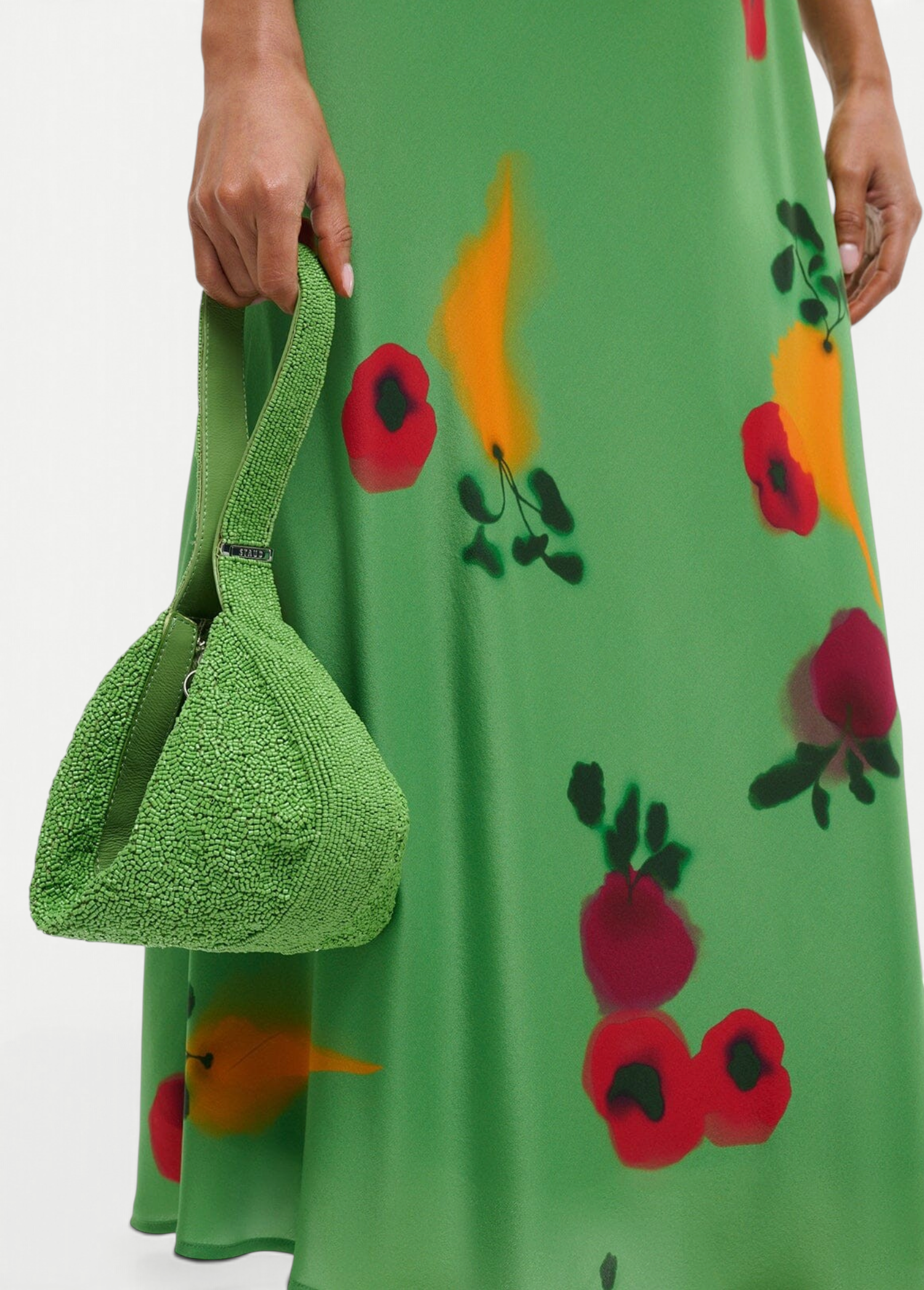 KABE SHOP INC Demy shoulder bag in green beaded texture held by a model wearing a matching floral print dress