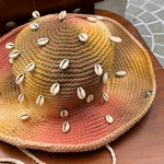 KABE SHOP INC Wika crochet hat featuring a vibrant tie-dye gradient and decorative white cowrie shells