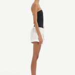 Model wearing KABE SHOP INC white lightweight cotton Charlie Rolled Shorts with a drawstring waist, side profile view