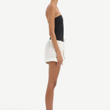 Model wearing KABE SHOP INC white lightweight cotton Charlie Rolled Shorts with a drawstring waist, side profile view