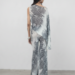 Model wearing KABE SHOP INC Luma Trousers in a floor-length, bias-cut viscose georgette with a black and white zebra print.