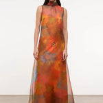 Sleeveless, floor-length Albee Dress with a high mock neck, featuring an abstract orange, red, and yellow floral print in a sheer fabric.