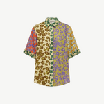 Patty Shirt, a short-sleeved button-up featuring a patchwork of floral prints in orange, brown, green, and purple, with ruffled cuffs for a contemporary touch.