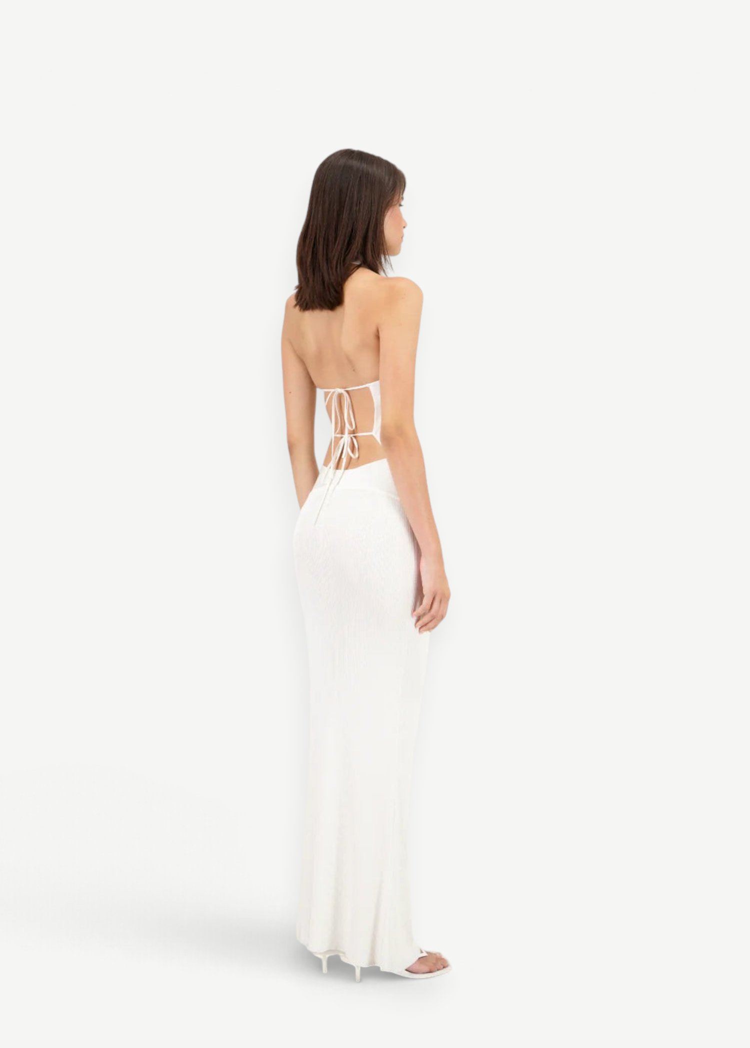 Model wearing a white KABE SHOP INC Classic Malageta maxi skirt with a matching backless tie-up top