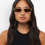 Woman wearing KABE SHOP INC Verve rectangular sunglasses with clear frames and brown lenses against a white background