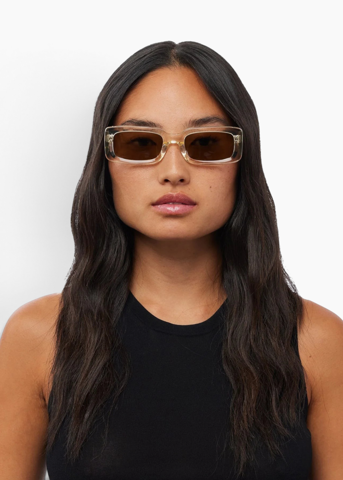 Woman wearing KABE SHOP INC Verve rectangular sunglasses with clear frames and brown lenses against a white background