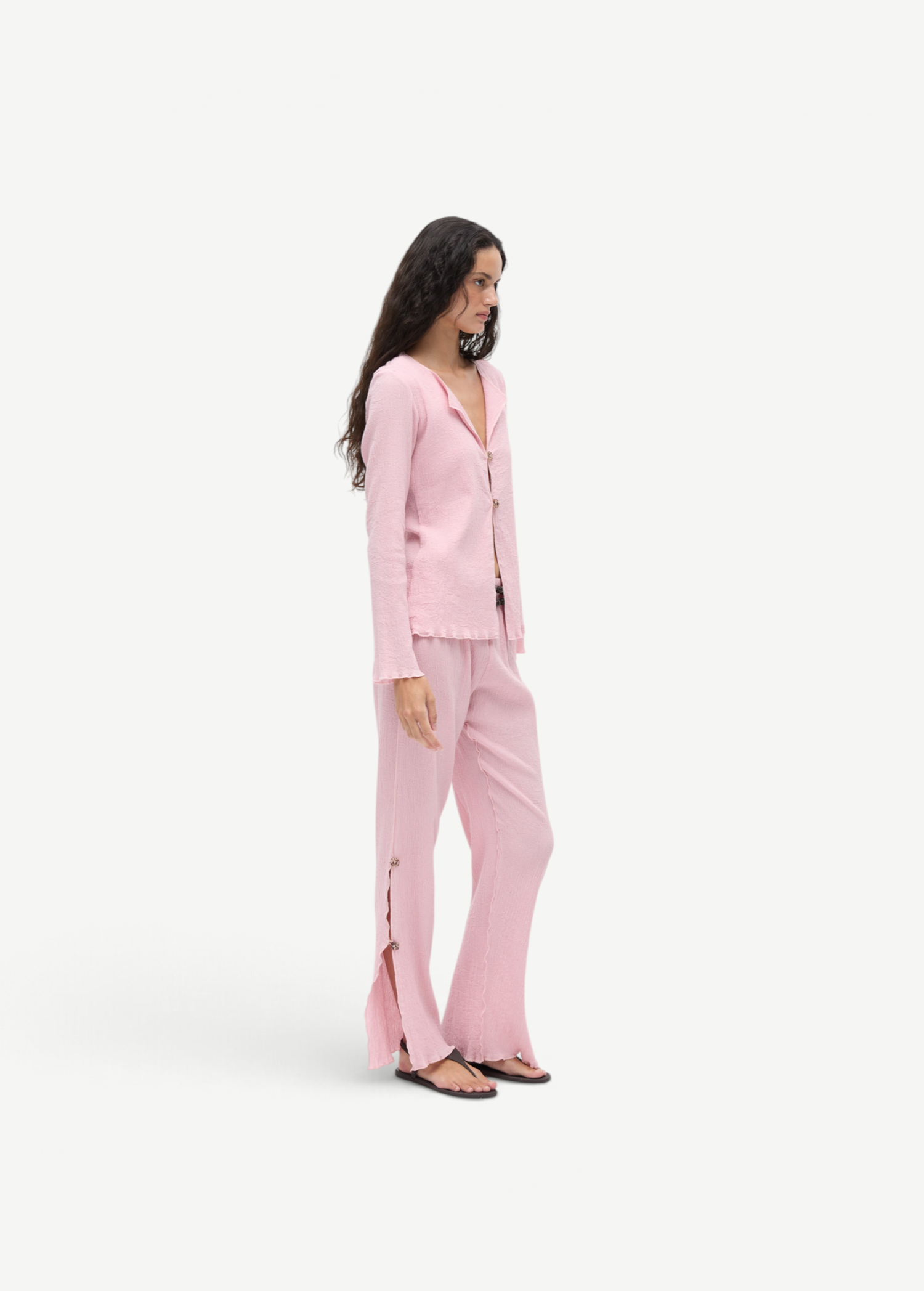 KABE SHOP INC Malaika pants in light pink with a textured finish, straight-leg silhouette, and side button detailing.