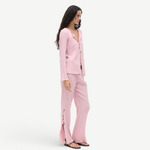 Model wearing KABE SHOP INC Malaika Top in light pink with textured fabric, oversized buttons, and matching trousers.