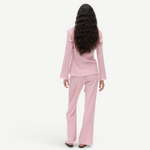 Back view of a woman wearing a KABE SHOP INC Malaika top and matching pants in a textured light pink fabric.