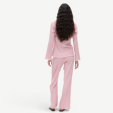 Back view of a woman wearing a KABE SHOP INC Malaika top and matching pants in a textured light pink fabric.