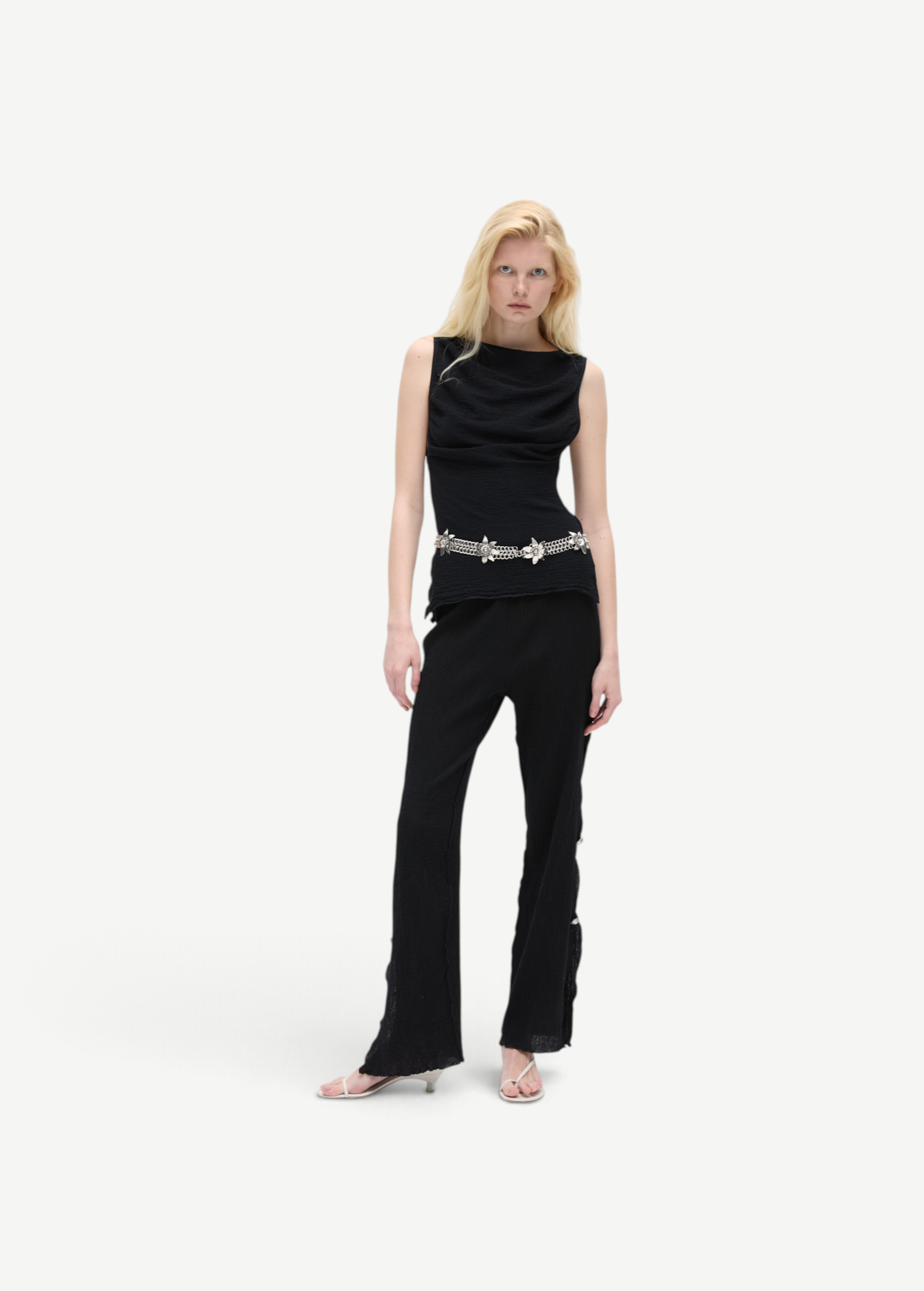KABE SHOP INC Malaika pants in black with a straight-leg silhouette, worn by a blonde model with a silver belt.