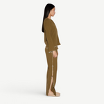 Model wearing KABE SHOP INC Malaika olive green straight-leg pants with side slit and contrast stitching