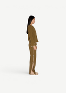 Model wearing KABE SHOP INC Malaika olive green straight-leg pants with side slit and contrast stitching