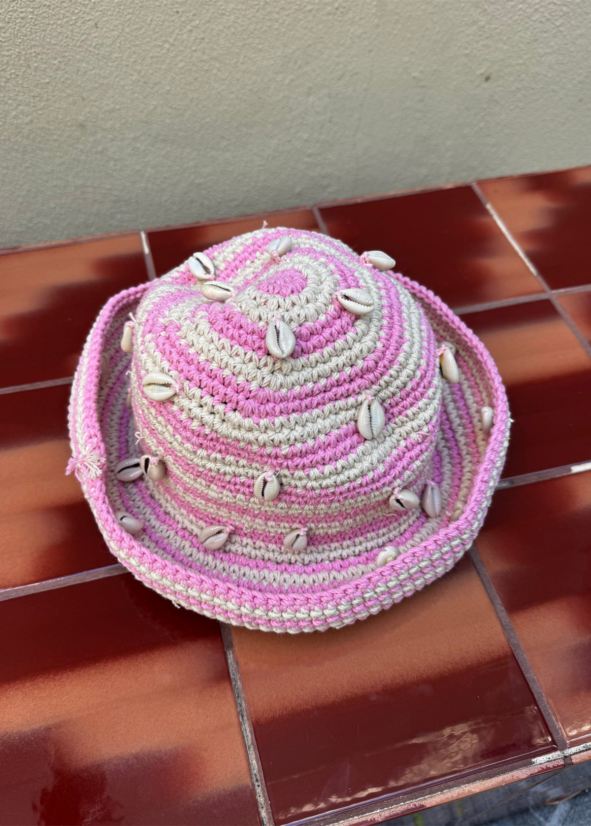 KABE SHOP INC handmade crochet hat in pink and beige with decorative sea shells, artisanal Tulum design