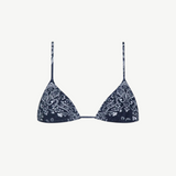 The Equator Top is a navy blue triangle bikini top with thin straps and a white paisley floral pattern. Made from ECONYL regenerated nylon, this adjustable bikini top offers a simple, minimalistic design for an effortlessly chic look.