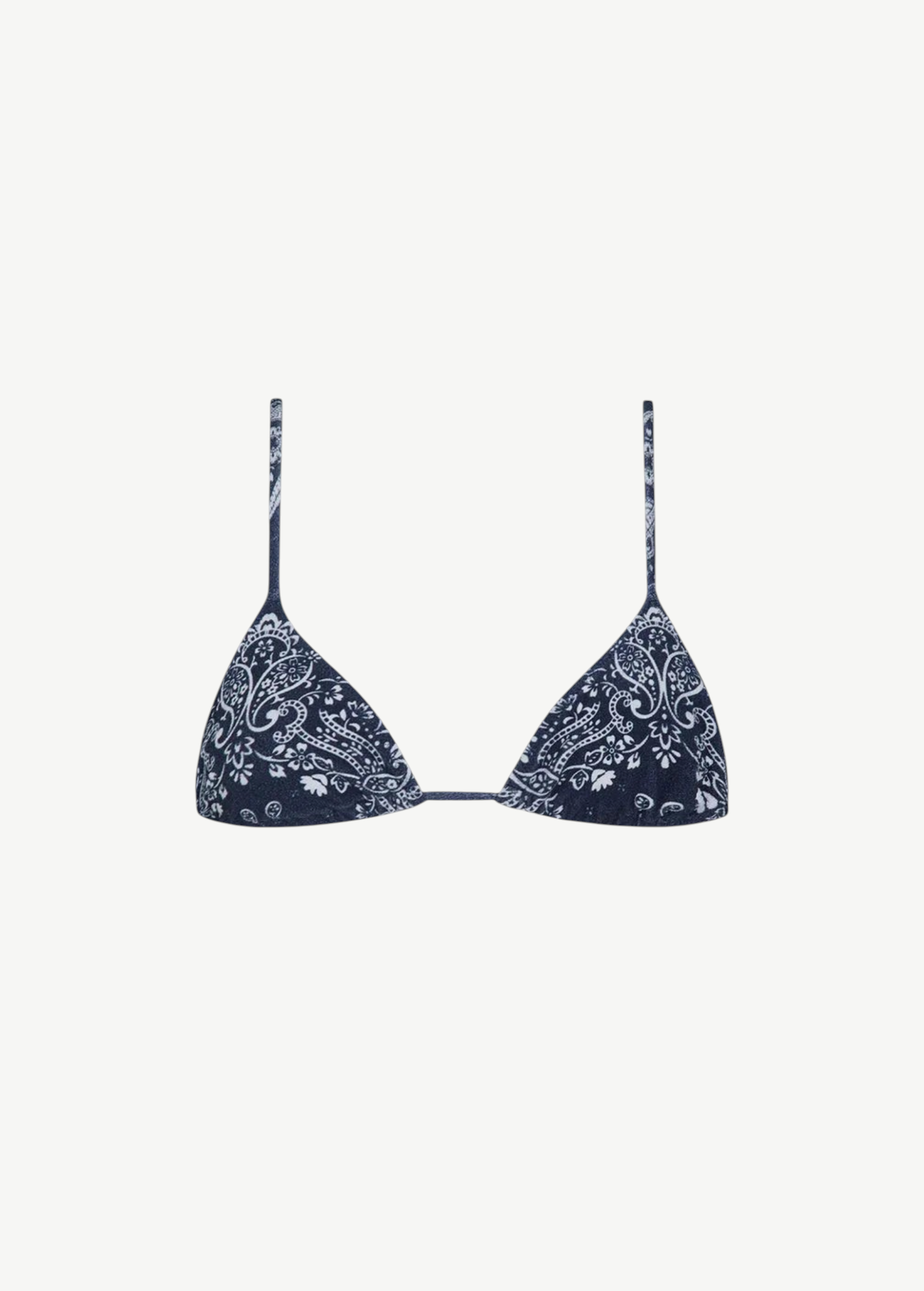 The Equator Top is a navy blue triangle bikini top with thin straps and a white paisley floral pattern. Made from ECONYL regenerated nylon, this adjustable bikini top offers a simple, minimalistic design for an effortlessly chic look.