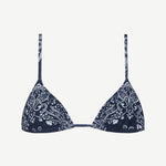 The Equator Top is a navy blue triangle bikini top with thin straps and a white paisley floral pattern. Made from ECONYL regenerated nylon, this adjustable bikini top offers a simple, minimalistic design for an effortlessly chic look.