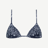 The Equator Top is a navy blue triangle bikini top with thin straps and a white paisley floral pattern. Made from ECONYL regenerated nylon, this adjustable bikini top offers a simple, minimalistic design for an effortlessly chic look.