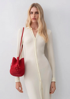 KABE SHOP INC The Hat Bag in vibrant red straw, worn as a shoulder bag by a model in a cream button-down dress.