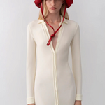 Model wearing a red KABE SHOP INC straw hat bag with a long chin strap, styled with a cream button-down midi dress.