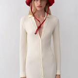 Model wearing a red KABE SHOP INC straw hat bag with a long chin strap, styled with a cream button-down midi dress.