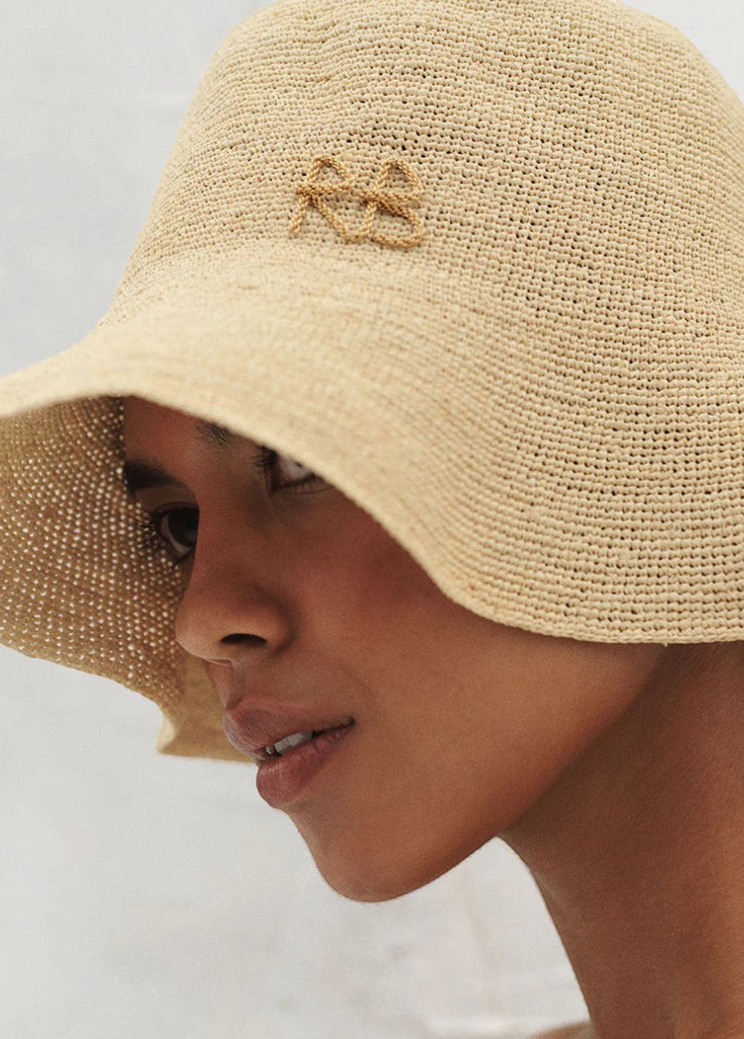 KABE SHOP INC beige woven bucket hat with embroidered monogram detail worn by a model