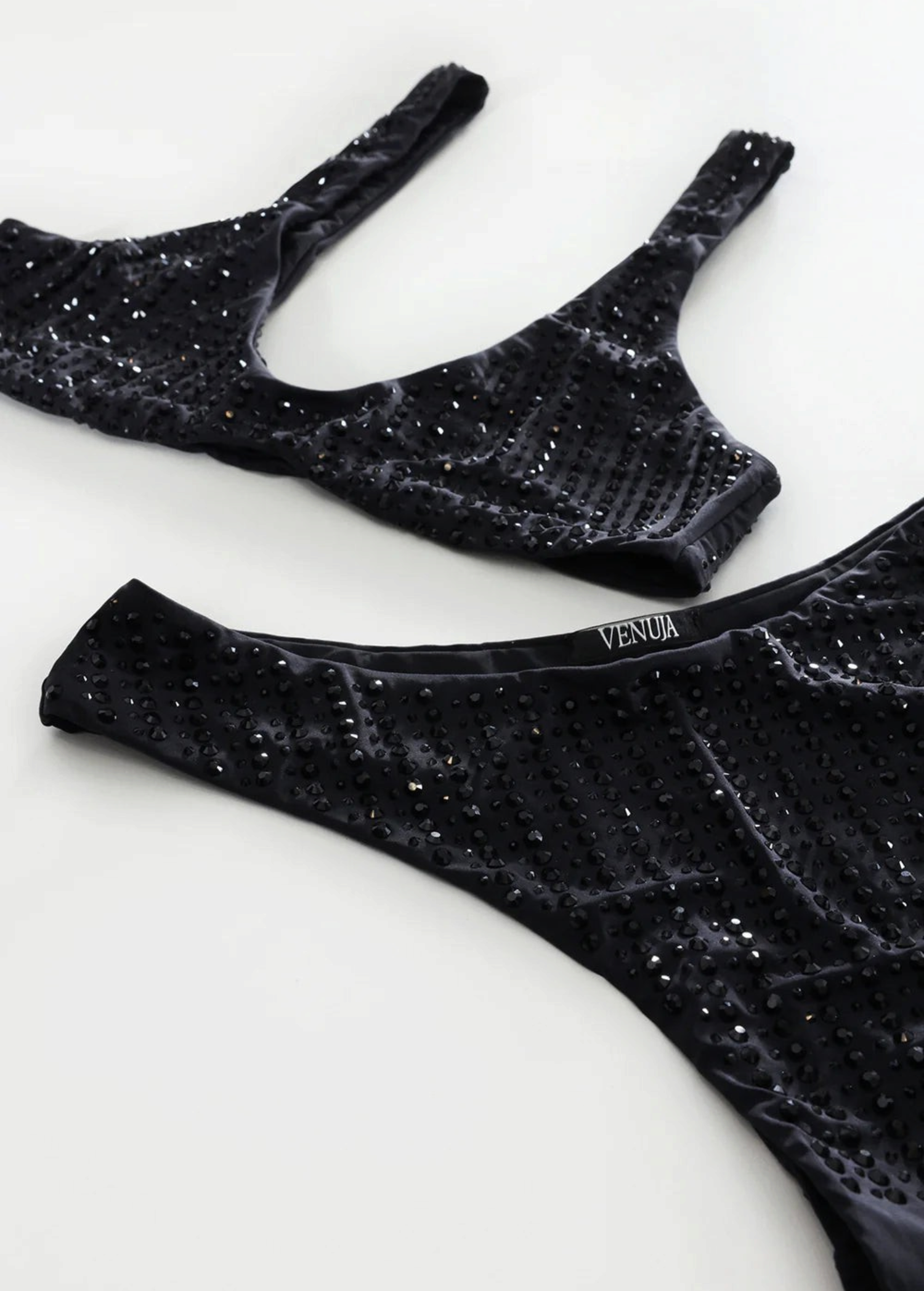 KABE SHOP INC black microfiber bikini set with high-cut Brazilian bottoms and rhinestone pinstripe embellishments.