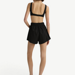 Model wearing KABE SHOP INC black Kyoto mini shorts in Japanese dry cotton with an elastic waist and tie belt, back view