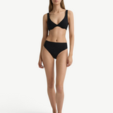 Model wearing a black KABE SHOP INC Gracie bikini top and matching high-waisted bottoms against a white background.