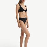 Model wearing KABE SHOP INC Gracie black bikini top with a supportive silhouette and matching high-waisted bottoms.