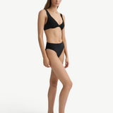 Model wearing KABE SHOP INC Gracie black bikini top with a supportive silhouette and matching high-waisted bottoms.