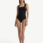 Model wearing a KABE SHOP INC Gwen black one-piece swimsuit with a square neckline and sculpting fit