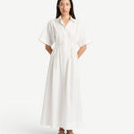 Model wearing a white KABE SHOP INC Kyoto lace-up shirt dress with short sleeves and a 7/8 length hem.