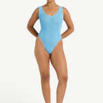 Model wearing KABE SHOP INC Mara light blue textured one-piece swimsuit with V-neck and high-cut leg