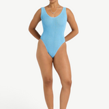 Model wearing KABE SHOP INC Mara light blue textured one-piece swimsuit with V-neck and high-cut leg