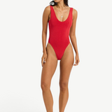 Model wearing KABE SHOP INC Mara red one-piece swimsuit with V-neckline and high-cut leg on a white background