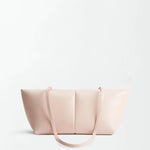 The Boulevard Sling Bag, crafted from light pink nappa leather, features two thin shoulder straps and is set against a plain white background. Its minimalist design showcases smooth leather with subtle stitching and a rectangular silhouette that curves elegantly at the sides.