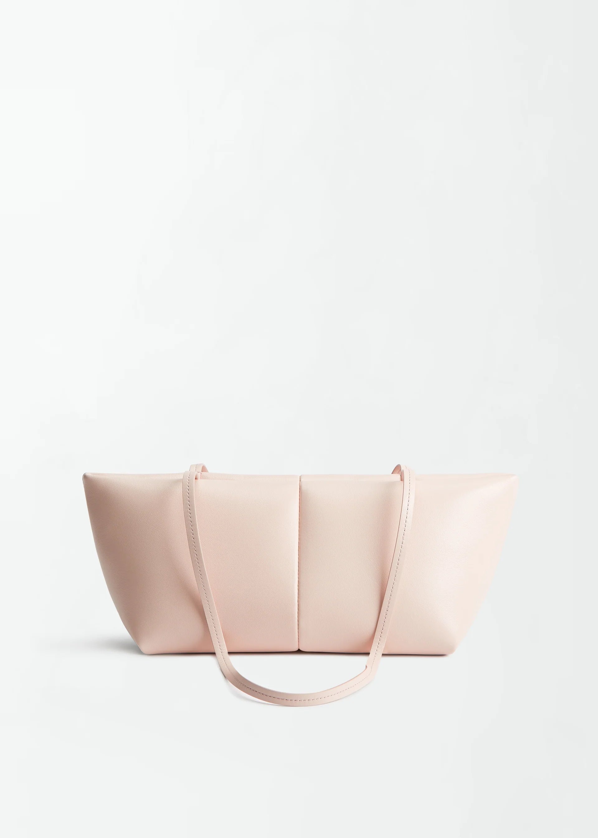 The Boulevard Sling Bag, crafted from light pink nappa leather, features two thin shoulder straps and is set against a plain white background. Its minimalist design showcases smooth leather with subtle stitching and a rectangular silhouette that curves elegantly at the sides.