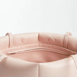 Close-up of the interior of the Boulevard Sling Bag in light pink nappa leather, featuring a zippered pocket and stitched details on soft, matte material.